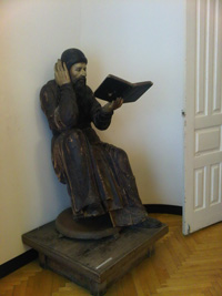 Экспозиция краеведческого музея. Деревянная скульптура Читающий монах